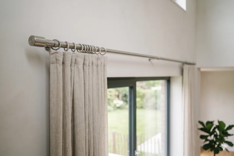 Gardinenstange mit Ringen über einem hellen Fenster